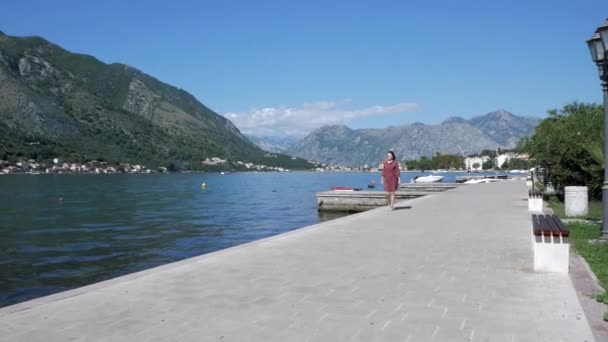 Donna cammina lungo il lungomare baia di Kotor e gode di una splendida vista. Kotor Montenegr — Video Stock