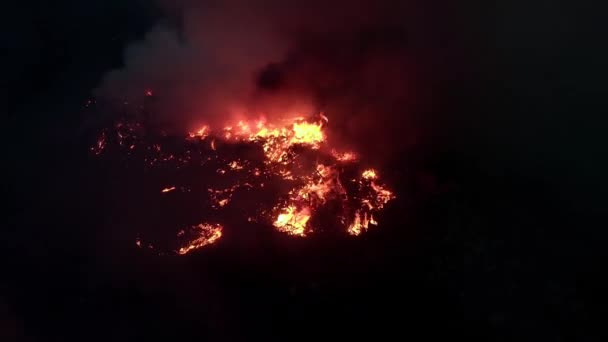 Tiro aéreo, de chama de fogo na noite escura. Um terrível fogo selvagem perigoso à noite num campo. Queimando grama de palha seca. Uma grande área da natureza está em chamas — Vídeo de Stock