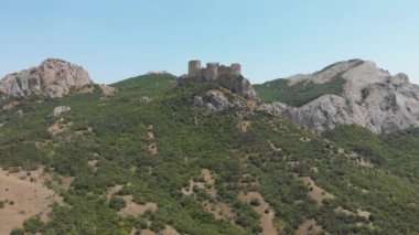 Dağın tepesindeki ortaçağ kalesinin havadan görünüşü, arka plandaki dağlardaki tahkimatlar. VFX