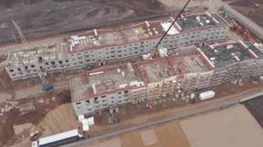 Çalışan inşaat sahasının 4k Aerial görüntüsü. İnşaat alanında çalışan birkaç vinç de dahil olmak üzere büyük inşaat sahası.