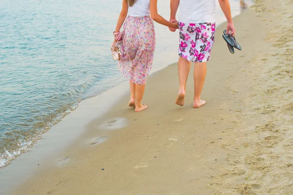 Casal de mãos dadas e caminhando ao longo da costa — Fotografia de Stock