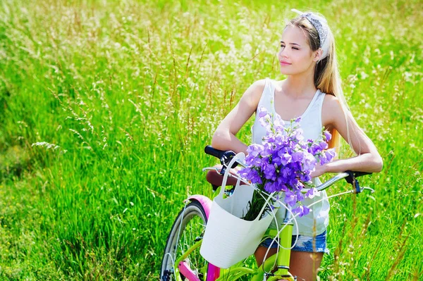 Young woman with her bike outdoors