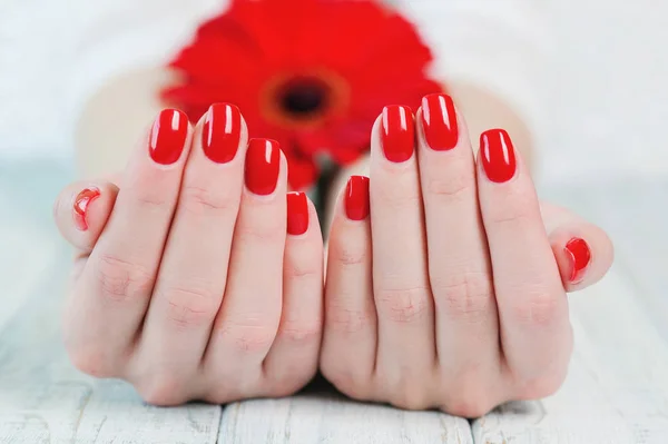 Vrouw handen met mooie rode manicure op nagels — Stockfoto