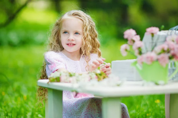 Happy little girl in blooming garden — Stock Photo, Image