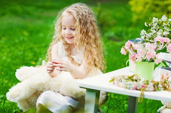 Happy little girl in blooming garden — Stock Photo, Image