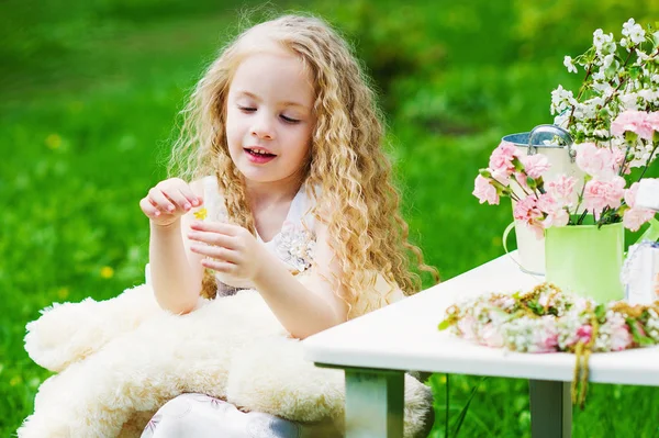 Happy little girl in blooming garden — Stock Photo, Image