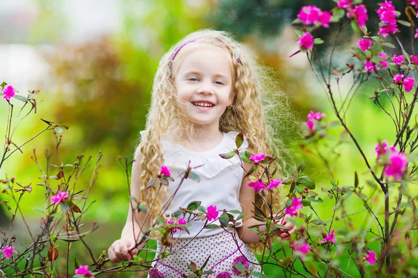 Happy little girl in blooming garden — Stock Photo, Image