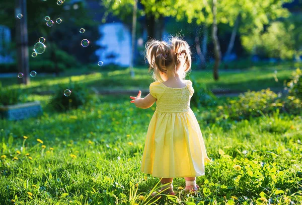 Menina bonito no parque de primavera jogando — Fotografia de Stock