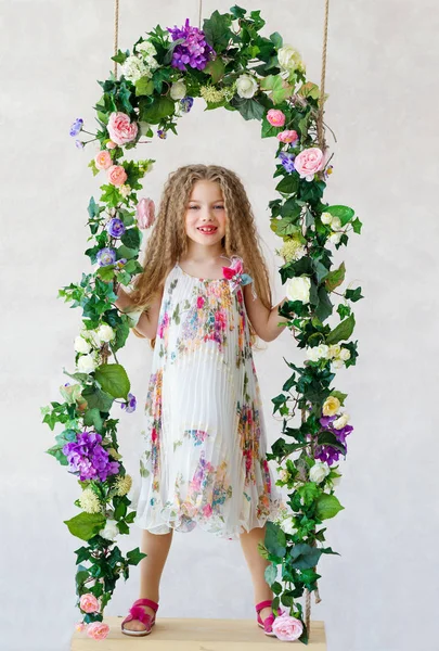 Beautiful girl on a flower swing — Stock Photo, Image