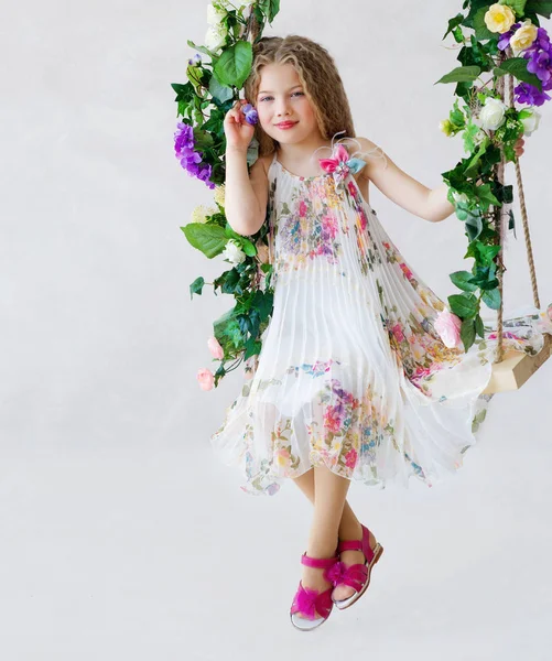 Beautiful girl on a flower swing — Stock Photo, Image