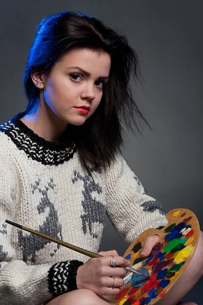 Kız bir kazaklı bir fırça ve palet