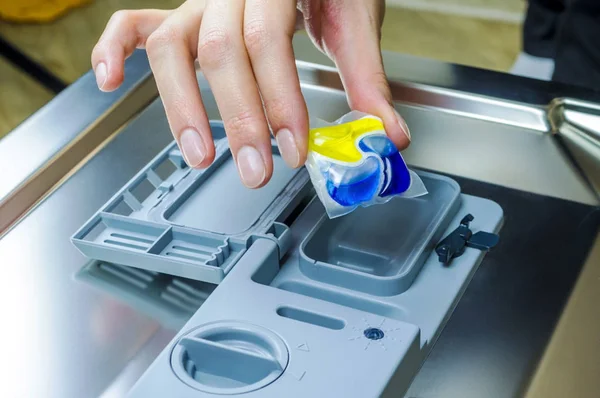 Anexar uma cápsula com detergente na máquina de lavar louça — Fotografia de Stock