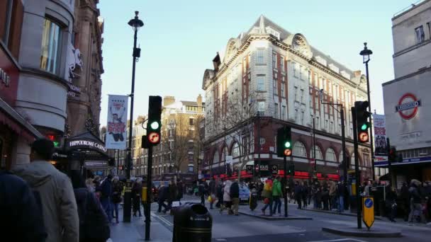 London, Verenigd Koninkrijk. 21 december. De kruising van Charing Cross Road en Cranbourn Street, rechts tegenover Leicester Square. Mensen lopen in de straat in sunset.ultra hd 4k — Stockvideo