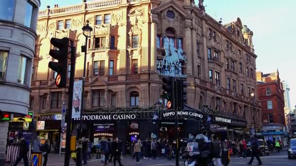 Londýn, Velká Británie. Dne 21. Křižovatky Charing Cross Road a Cranbourne Street, přímo naproti náměstí Leicester Square. Lidé chodí po ulici v sunset.ultra hd 4k — Stock video