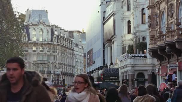 LONDRES, Reino Unido. 21 de Dezembro. A junção da Charing Cross Road com a Cranbourn Street, em frente à Leicester Square. As pessoas descem a rua ao pôr do sol.ultra hd 4k — Vídeo de Stock