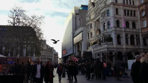 London, Wielka Brytania. Grudnia 21. Na skrzyżowaniu Charing Cross Road i Cranbourn Street, dokładnie naprzeciwko Leicester Square. Ludzie chodzą ulicą w sunset.ultra hd 4k — Wideo stockowe