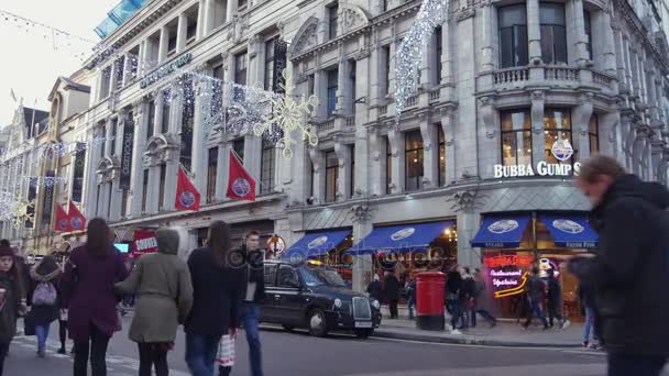 Londra - Aralık 19: Noel ışıkları ekran Regent Caddesi üzerinde Aralık 19, Londra, İngiltere. Modern renkli Noel ışıkları çekmek ve insanlar sokaklarda teşvik. — Stok video