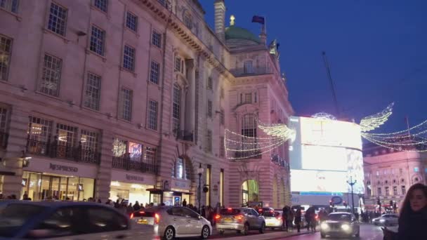 Londra - Aralık 19: Noel ışıkları ekran Regent Caddesi üzerinde Aralık 19, Londra, İngiltere. Modern renkli Noel ışıkları çekmek ve insanlar sokaklarda teşvik. — Stok video