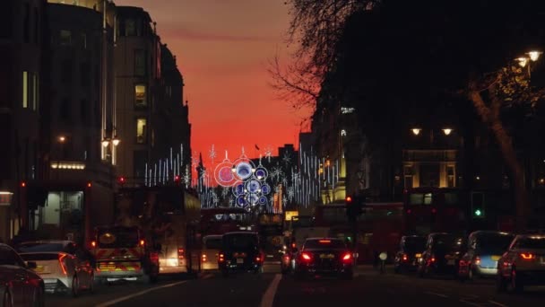 ЛОНДОН, Великобритания - DEC 19: Рождественские огни на Стрэнд-стрит 19 декабря, в сумерках. Современные красочные рождественские огни привлекают и поощряют людей на улицу . — стоковое видео