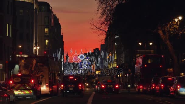 Londra, İngiltere - Aralık 19: Noel ışıkları Strand Street 19 Aralık, alacakaranlıkta ekranda. Modern renkli Noel ışıkları çekmek ve insanlar sokaklarda teşvik. — Stok video