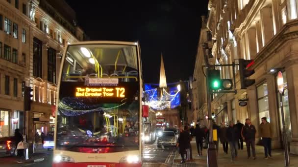 London - DEC 2016: Christmas lights and London buses at the station on busy Oxford Street London, England, United Kingdom in December, 2016. Oxford circus at traffic rush. — Stock Video