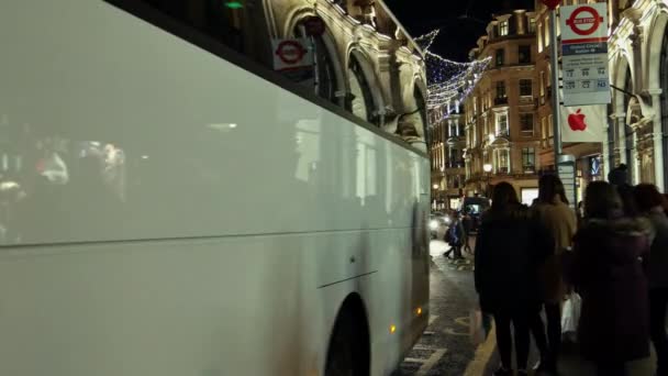 Londra - Aralık 19: Noel ışıkları ekran Regent Caddesi üzerinde Aralık 19, Londra, İngiltere. Modern renkli Noel ışıkları çekmek ve insanlar sokaklarda teşvik. — Stok video