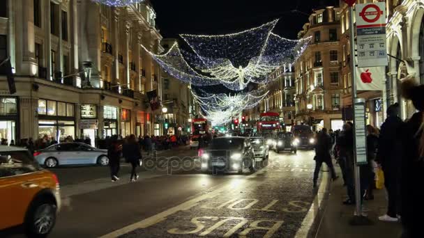 Londyn - Dec 19: Christmas Lights wyświetlacz na Regent Street 19 Dec, Londyn, Wielka Brytania. Nowoczesne kolorowe Boże Narodzenie światła przyciągają i zachęcają ludzi do ulicy. — Wideo stockowe