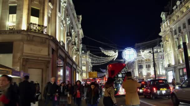 Londýn - prosinec 19: Vánoční osvětlení displeje na Regent Street na Dec 19, Londýn, Velká Británie. Moderní barevné vánoční osvětlení přilákat a povzbudit lidi, aby na ulici. — Stock video