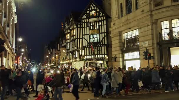 London - Dec 19: Karácsonyi fények kijelző, a Regent Street, december 19-én, London, Egyesült Királyság. A modern, színes karácsonyi fények vonzza és ösztönözze az embereket az utcán. — Stock videók