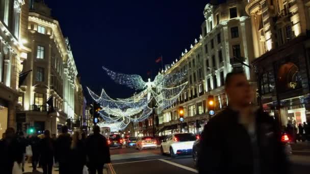 Londýn - prosinec 19: Vánoční osvětlení displeje na Regent Street na Dec 19, Londýn, Velká Británie. Moderní barevné vánoční osvětlení přilákat a povzbudit lidi, aby na ulici. — Stock video