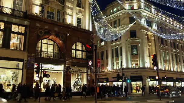 Londen - 19 Dec: Christmas Lights Display op Regent Street op 19 Dec, London, Verenigd Koninkrijk. De moderne kleurrijke Kerstverlichting trekken en moedigen mensen aan de straat. — Stockvideo