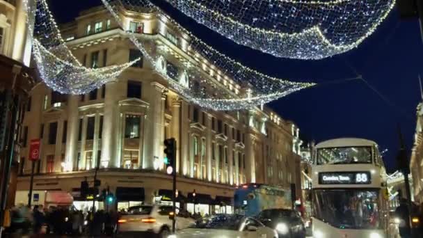 Londen - 19 Dec: Christmas Lights Display op Regent Street op 19 Dec, London, Verenigd Koninkrijk. De moderne kleurrijke Kerstverlichting trekken en moedigen mensen aan de straat. — Stockvideo