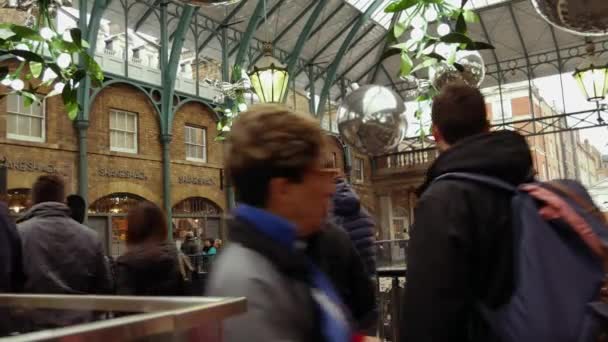 LONDRES, Reino Unido - 20 DE DICIEMBRE DE 2016: Los compradores disfrutan de las decoraciones navideñas en el mercado Covent Garden, 4k Ultrahd — Vídeo de stock