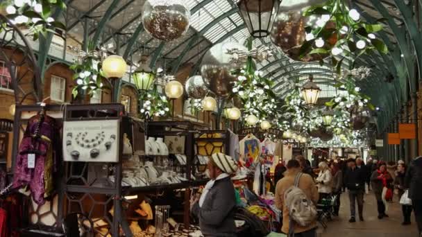 London, Egyesült Királyság - 2016. December 20.: A vásárlók élvezni a karácsonyi díszek, Covent Garden piacon, 4k Ultrahd — Stock videók