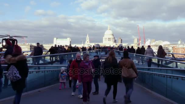 LONDRES, Reino Unido - 20 DE DEZEMBRO DE 2016: Pessoas caminhando sobre a ponte do Milênio. É uma ponte suspensa com um comprimento total de 370 metros (1.214 pés) e uma largura de 4 metros (13 pés) .ultra hd 4k, em tempo real . — Vídeo de Stock