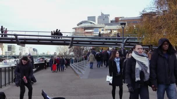 Londra, İngiltere - 20 Aralık 2016: Millennium Köprüsü üzerinde yürüyen insanlar. Onun bir asma köprü ile 370 metre (1,214 ft) toplam uzunluğu ve genişliği 4 m (13 ft) .ultra hd 4k, gerçek zamanlı. — Stok video