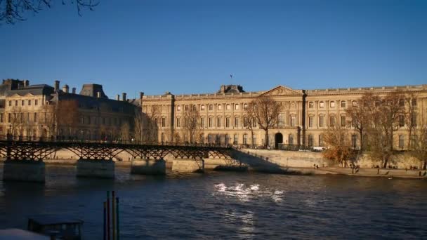 Париж, Франция - около 2016 года: Люди прогуливаются по мосту Ponts des Arts с экскурсионными лодками по реке Сена, ультра hd 4k — стоковое видео