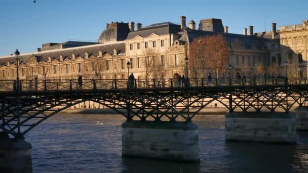 Paris, França-circa 2016: As pessoas caminham ao longo da ponte Ponts des Arts com barcos turísticos no rio Sena, ultra hd 4k — Vídeo de Stock