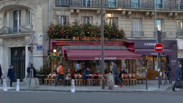 PARIS, FRANÇA - 06 de dezembro de 2016: Rua da cidade com vista para o restaurante vermelho, café ao ar livre e pessoas cruzando a estrada, ultra hd 4k — Vídeo de Stock
