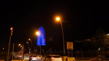 Yaklaşık 2017:Torre Agbar Barcelona, Barselona, İspanya. 38 katlı gökdelen. Barcelona salatalık. İspanya. Trafik araçları ile gece görünümü.