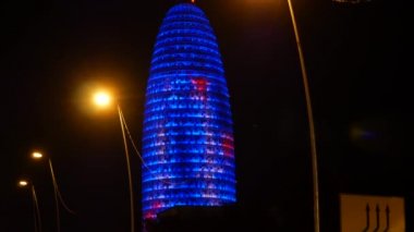 Yaklaşık 2017:Torre Agbar Barcelona, Barselona, İspanya. 38 katlı gökdelen. Barcelona salatalık. İspanya. Trafik araçları ile gece görünümü.