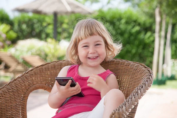 little child on chair with mobile looking and laughing