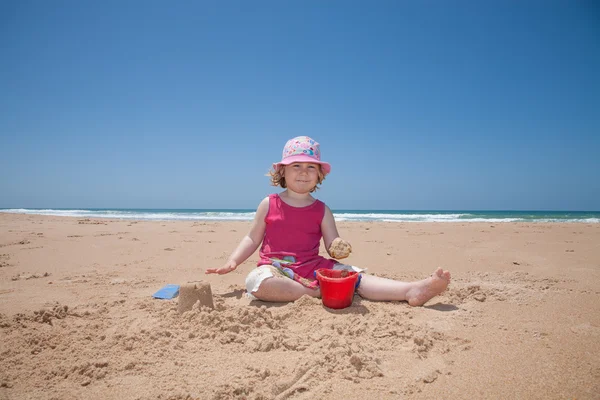 Menina brincando com brinquedos de praia na praia | Foto 
