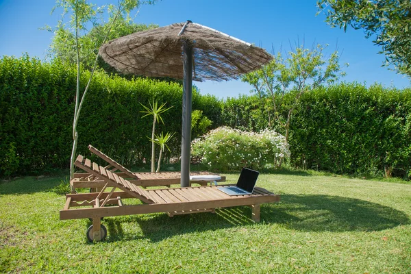 Lonely open laptop on wooden lounge chair — Stock Photo, Image