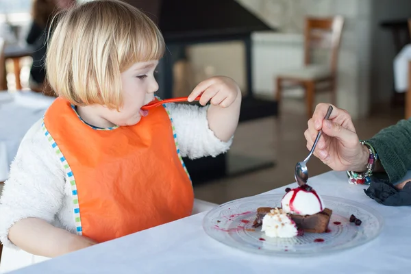 Kleines Kind isst mit Frau Schokoladenkuchen — Stockfoto