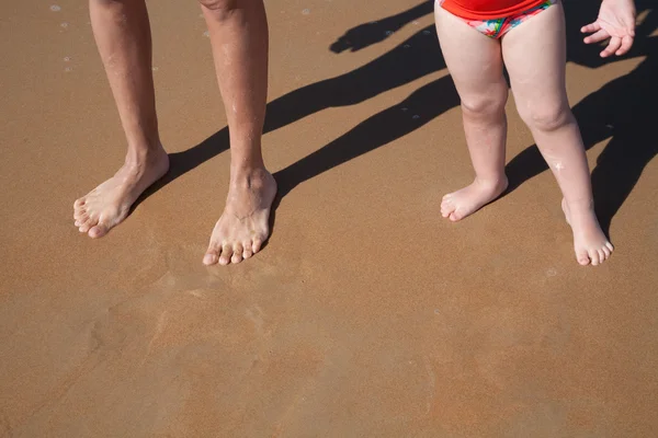 Mulher e criança descalça os pés na areia da praia — Fotografia de Stock