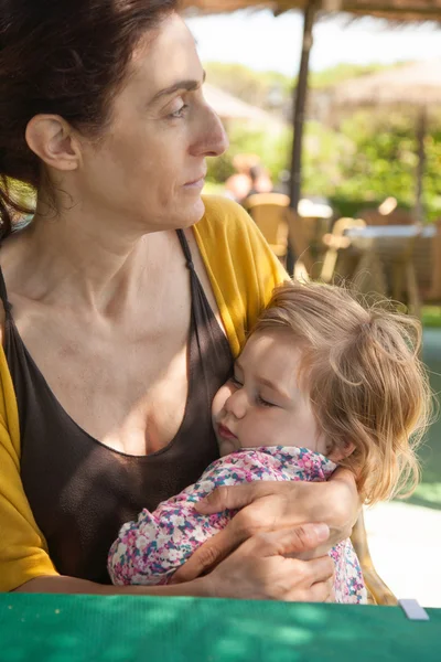 彼女の腕で眠っている小さな子供を持つ女性 — ストック写真