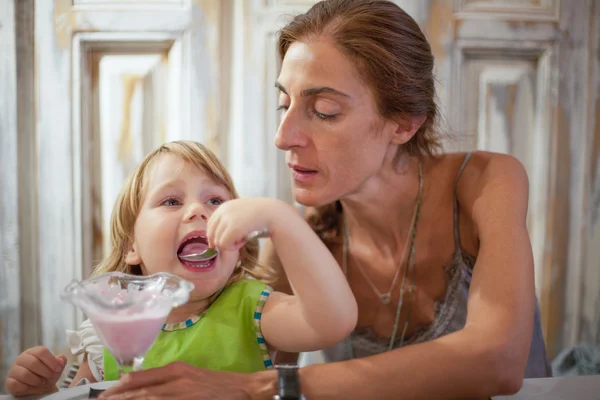 Pequeño niño comiendo helado con la madre en el restaurante —  Fotos de Stock