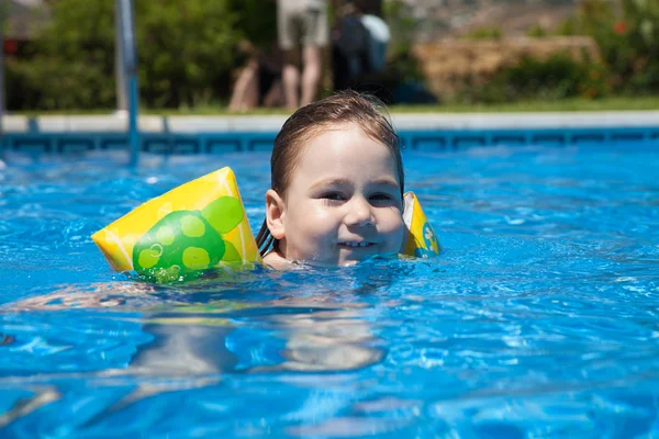 Looking child with sleeves in pool — Stock Photo, Image