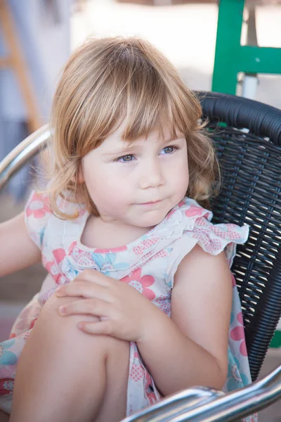 Портрет красивой маленькой девочки, сидящей и смотрящей — стоковое фото